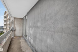 Exterior balcony featuring a concrete floor, concrete wall, and metal railing - 