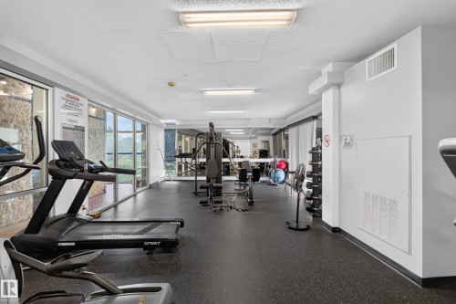 Fitness center featuring extensive full-height windows, durable black rubber flooring, and bright overhead fluorescent lighting - #1804 10883 Saskatchewan Dr Nw, Edmonton, AB - Indoor Photo Showing Gym Room