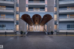 Multi-story building entrance with a covered portico featuring three arched wood-paneled ceilings and integrated lighting - 