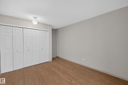 Room featuring white bi-fold closet doors, wood-finish flooring, light neutral wall paint, and a semi-flush ceiling light fixture - 
