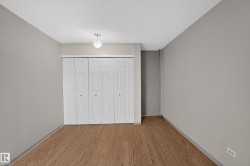 Interior room featuring wood-finish flooring, light gray wall paint, and white trim - 