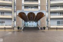 Building entrance featuring a contemporary arched porte-cochère with wood-finish soffits and recessed lighting - #1508 10883 Saskatchewan Dr Nw Nw, Edmonton, AB  - Outdoor With Balcony 