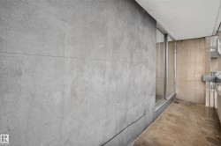 Balcony featuring concrete flooring, sliding glass door, metal railing, and concrete exterior wall - 