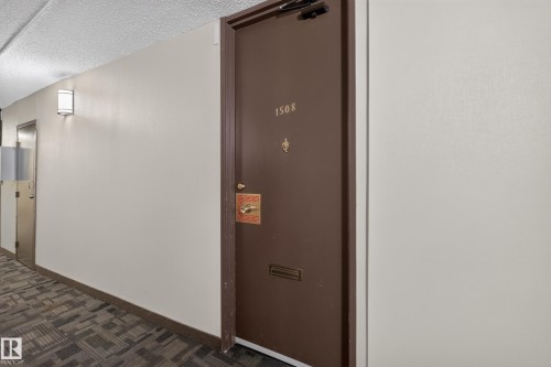 Entry door with brass hardware, featuring a mail slot and visible unit number - #1508 10883 Saskatchewan Dr Nw Nw, Edmonton, AB - Indoor