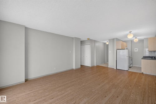 Open-concept living area featuring wood-finish flooring, light gray wall paint, and a textured white ceiling - #1508 10883 Saskatchewan Dr Nw Nw, Edmonton, AB - Indoor Photo Showing Kitchen