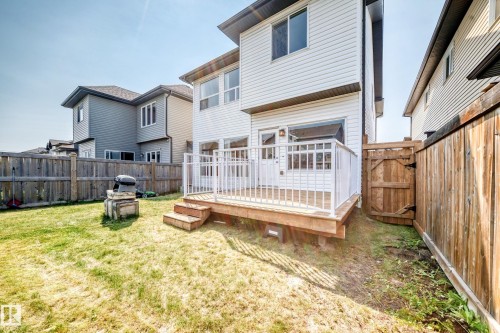 Rear exterior featuring a wood deck with white railings, a multi-panel door with glass inserts, and a wood-slat privacy fence - 2923 16 Street Nw, Edmonton, AB - Outdoor With Deck Patio Veranda With Exterior