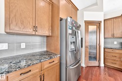 Rear exterior featuring a wood deck with white railings, a multi-panel door with glass inserts, and a wood-slat privacy fence - 