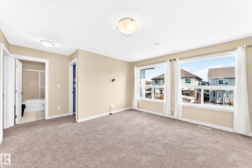 Spacious room featuring broadloom carpet flooring and multiple large windows - 2923 16 Street Nw, Edmonton, AB - Indoor Photo Showing Other Room