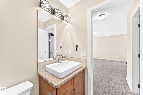 Bathroom vanity featuring a vessel sink, chrome faucet, and a granite-finish countertop - 2923 16 Street Nw, Edmonton, AB - Indoor Photo Showing Bathroom