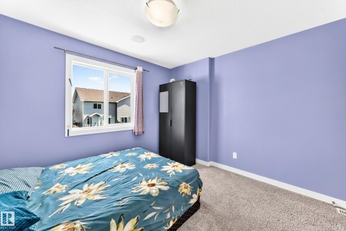 Carpeted room featuring a white-framed window, flush-mount ceiling light fixture, and white baseboards - 2923 16 Street Nw, Edmonton, AB - Indoor Photo Showing Bedroom