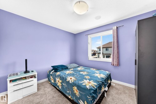 Room featuring light purple walls, a single window with white trim, and a ceiling-mounted light fixture - 2923 16 Street Nw, Edmonton, AB - Indoor Photo Showing Bedroom
