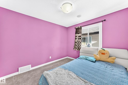 Bedroom featuring vibrant magenta walls and gray carpet flooring - 2923 16 Street Nw, Edmonton, AB - Indoor Photo Showing Bedroom