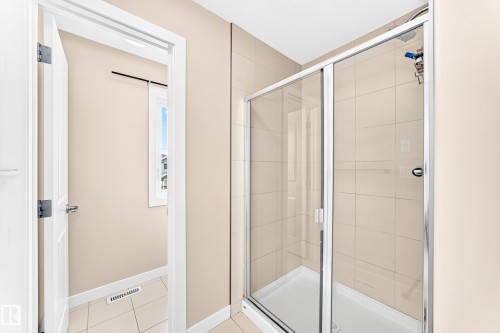 Glass-enclosed shower with a tiled surround, chrome fixtures, and a white shower pan - 2923 16 Street Nw, Edmonton, AB - Indoor Photo Showing Bathroom