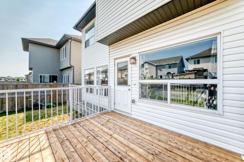 Exterior wood deck with white metal railings, white vinyl siding, and a white exterior door - 2923 16 Street Nw, Edmonton, AB - Outdoor With Deck Patio Veranda With Exterior