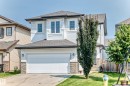 Two-story residence featuring white siding, a dark shingle roof, and a single-car garage with a panel door - 2923 16 Street Nw, Edmonton, AB  - Outdoor With Facade 