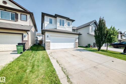 Contemporary two-story residence featuring light-colored siding, a dark pitched roof, and a two-car garage with a concrete driveway - 2923 16 Street Nw, Edmonton, AB - Outdoor With Facade