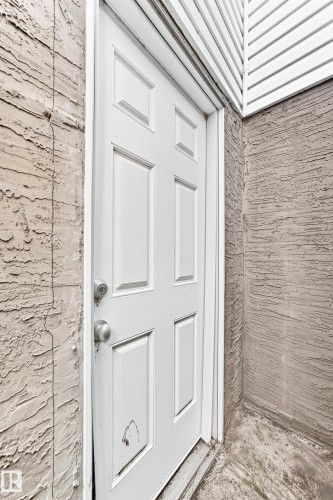 White six-panel door with a metal knob and deadbolt - 2923 16 Street Nw, Edmonton, AB - Outdoor With Exterior