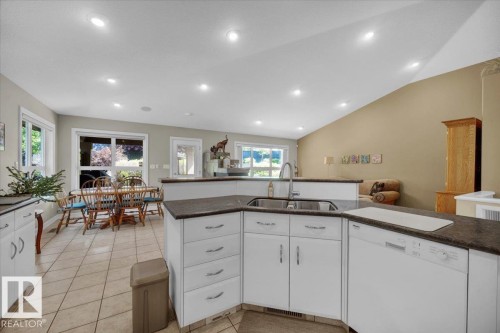 Kitchen featuring white cabinetry, dark countertops, a double basin sink, and a built-in dishwasher - 928 Thompson Place Nw, Edmonton, AB - Indoor Photo Showing Kitchen
