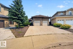 Stucco exterior with a two-car garage and concrete driveway - 