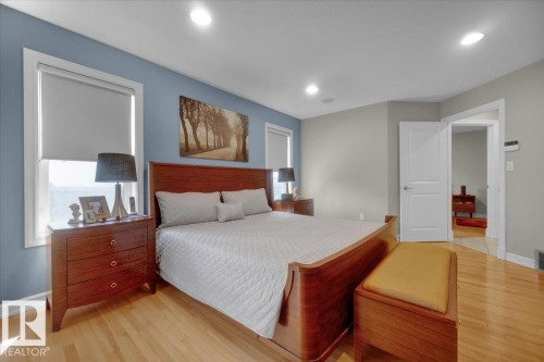 Hardwood flooring throughout the room, complemented by recessed lighting and a ceiling-mounted speaker - 928 Thompson Place Nw, Edmonton, AB - Indoor Photo Showing Bedroom