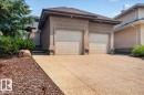 Exterior featuring a two-car garage, concrete driveway, front entrance steps, and diverse landscaping with mature trees and shrubs - 928 Thompson Place Nw, Edmonton, AB  - Outdoor 