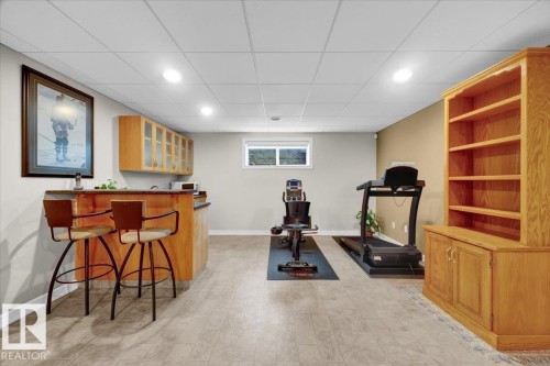 Finished lower level featuring a wet bar with wood-finish cabinetry, recessed lighting, and light-tone flooring - 928 Thompson Place Nw, Edmonton, AB - Indoor Photo Showing Other Room