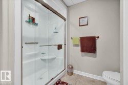 White acrylic shower enclosure with sliding glass doors, integrated shelving, and a built-in corner seat - 