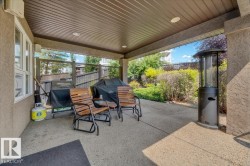 Covered patio featuring an exposed aggregate concrete surface, recessed lighting, and a stucco exterior finish - 