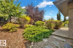 Beautifully landscaped grounds featuring mature trees, ornamental shrubs, and layered plantings throughout the yard - 