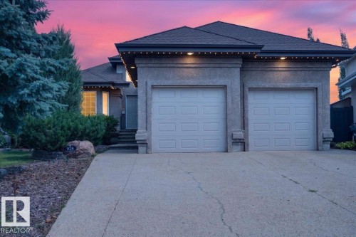 Stucco exterior home featuring a concrete driveway and an integrated two-car garage - 928 Thompson Place Nw, Edmonton, AB - Outdoor