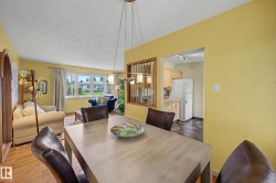 Dining area featuring a contemporary pendant light fixture, wood-finish flooring, and an arched entryway - 
