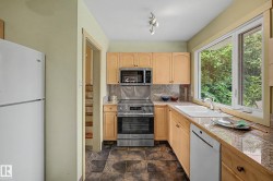 Kitchen featuring wood cabinetry, stone countertops, a stainless steel range, and a large window - 