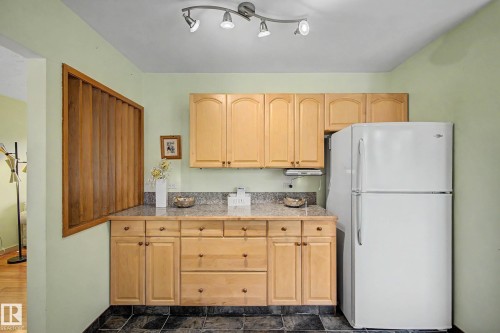 Kitchen area with natural wood cabinetry and a gray speckled countertop - 9516 129A Avenue Nw, Edmonton, AB - Indoor Photo Showing Kitchen