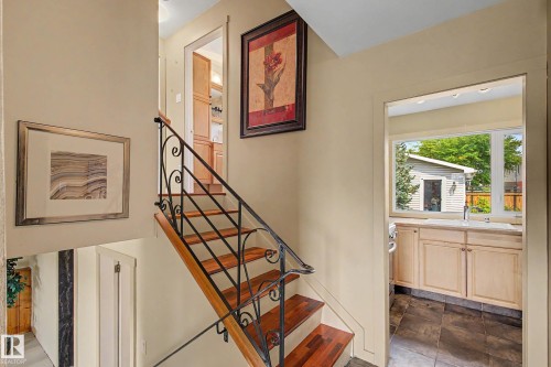 Staircase featuring wood-finish treads and an ornamental wrought iron railing - 9516 129A Avenue Nw, Edmonton, AB - Indoor Photo Showing Other Room