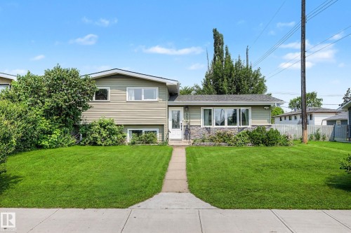 Split-level home featuring light green siding and a stone facade - 9516 129A Avenue Nw, Edmonton, AB - Outdoor