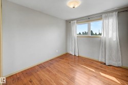 Room with wood-finish flooring, light grey walls, and a multi-pane window - 