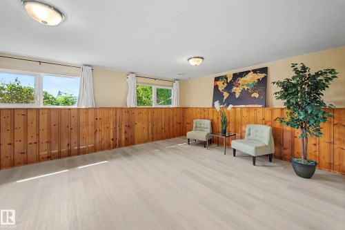 Spacious room featuring light wood-finish flooring, natural wood paneling, and multiple windows - 9516 129A Avenue Nw, Edmonton, AB - Indoor Photo Showing Other Room