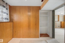 Carpeted room with wood paneling and a window - 
