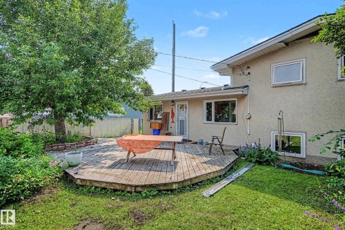 Expansive backyard featuring a multi-level wooden deck, mature tree, and perimeter fencing - 9516 129A Avenue Nw, Edmonton, AB - Outdoor