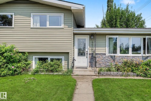 Split-level residence featuring a textured siding exterior and a stone veneer accent wall - 9516 129A Avenue Nw, Edmonton, AB - Outdoor
