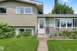 Split-level residence featuring a textured siding exterior and a stone veneer accent wall - 