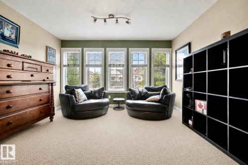 Room featuring light-colored carpeting and a bank of three windows with blinds - 416 Sparling Crest Sw, Edmonton, AB - Indoor