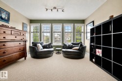 Room featuring light-colored carpeting and a bank of three windows with blinds - 