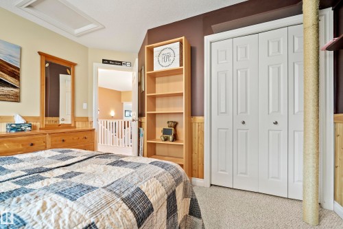 Bedroom featuring neutral carpet flooring, wood wainscoting, and a multi-paneled bi-fold closet - 416 Sparling Crest Sw, Edmonton, AB - Indoor Photo Showing Bedroom