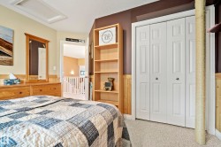Bedroom featuring neutral carpet flooring, wood wainscoting, and a multi-paneled bi-fold closet - 