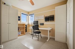 Room featuring two windows, neutral carpeting, and a ceiling fan - 