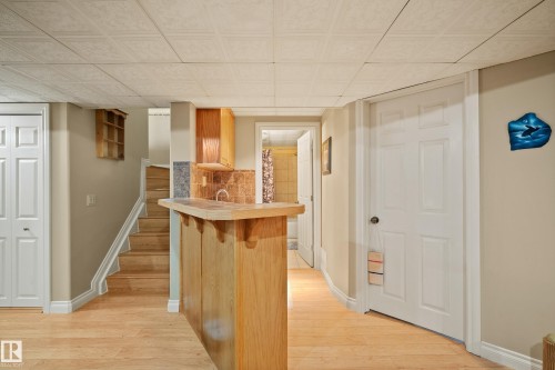 Lower level featuring a wet bar with wood cabinetry, a tiled backsplash, and a sink - 416 Sparling Crest Sw, Edmonton, AB - Indoor Photo Showing Other Room