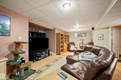 Finished basement living area featuring neutral wall colors, drop ceiling, and recessed lighting - 