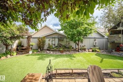 Expansive backyard featuring artificial turf, mature trees, and a landscaped rock garden - 