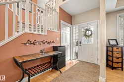 Entryway featuring wood-finish flooring, a white paneled entry door with leaded glass, and a closet with bifold doors - 